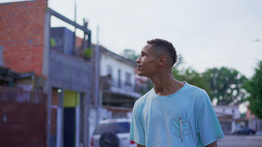 One pensive young black Brazilian man looking up at sky in contemplative and thoughtful expression. 