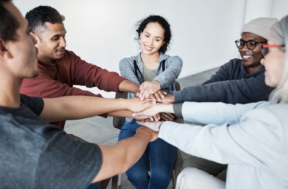 A diverse group of individuals engaged in a supportive therapy session