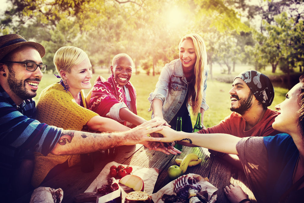 A diverse group of people sitting outdoors, laughing and talking, representing free addiction treatment support